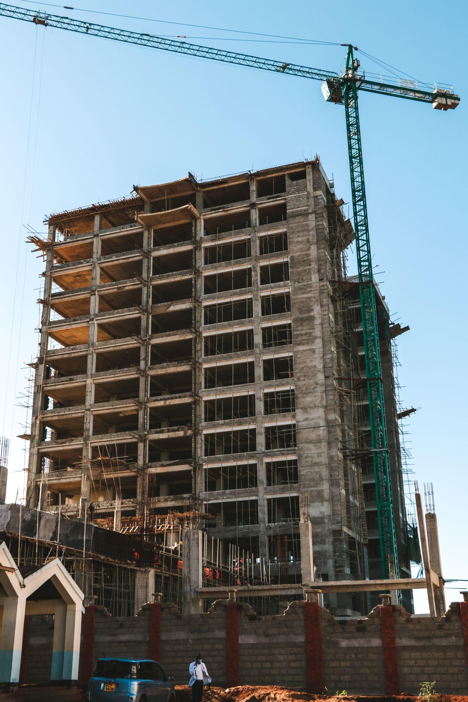 A high-rise building under construction with a tower crane