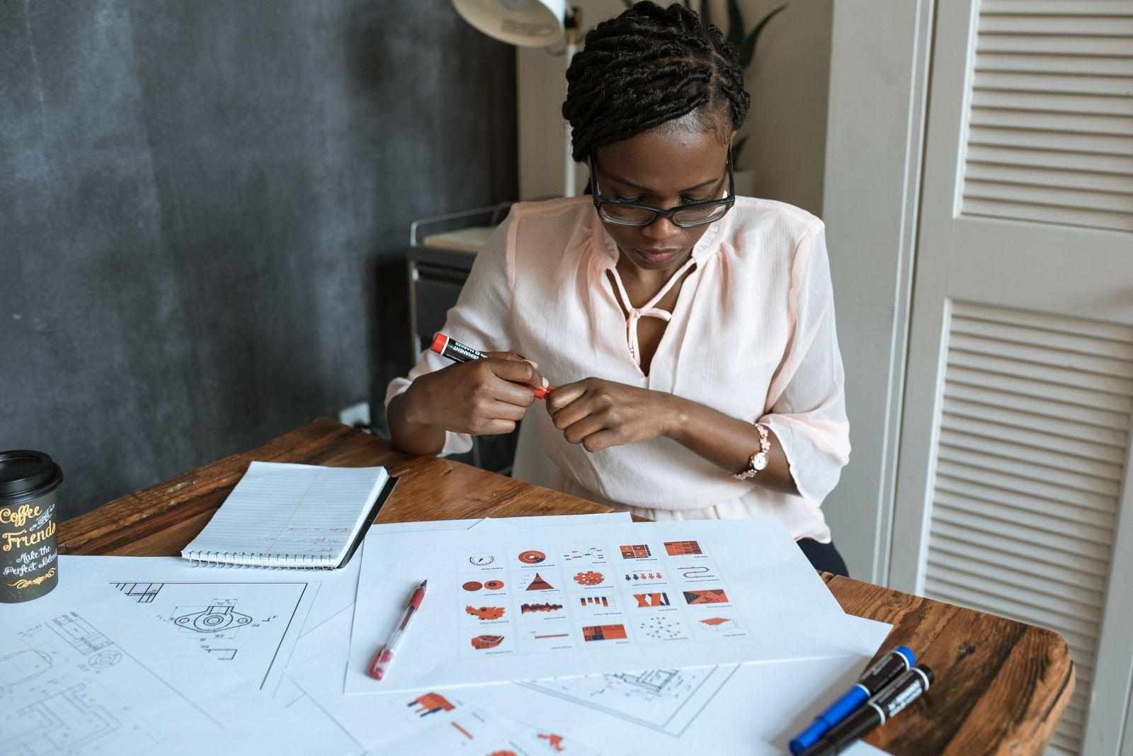 A consultant working through printed documents at her desk