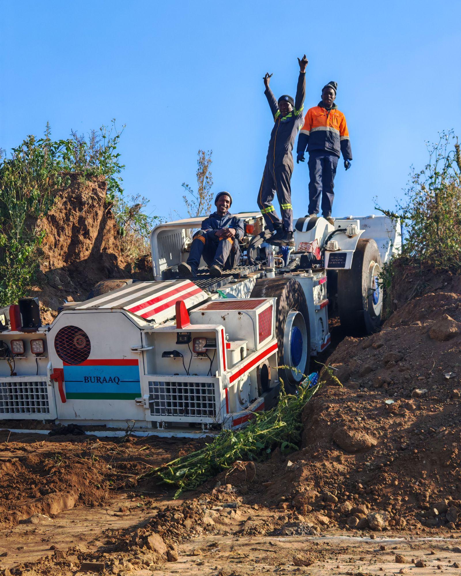 Miners standing on heavy mining equipment