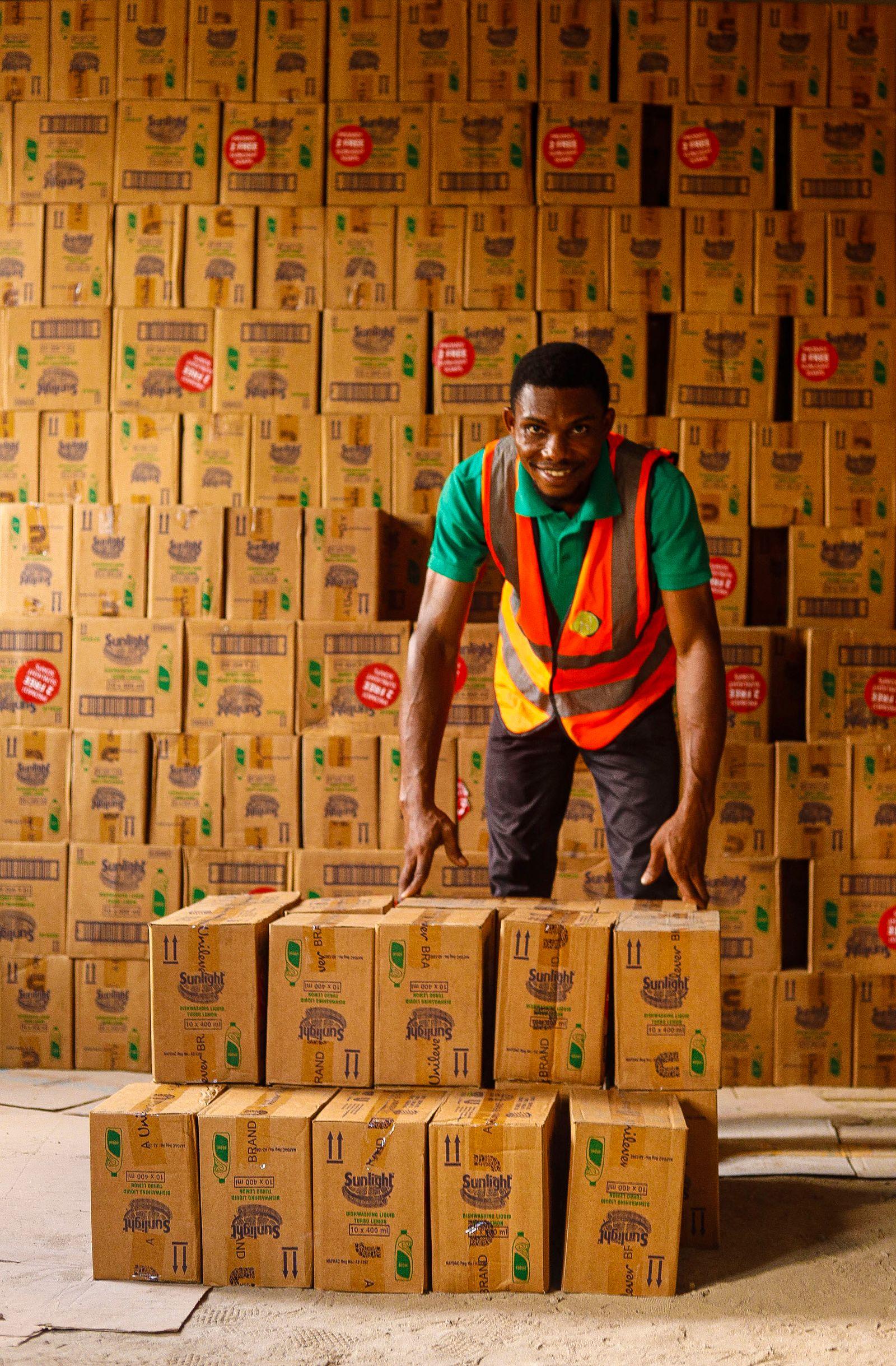 A warehouse worker checking stacked boxes of goods