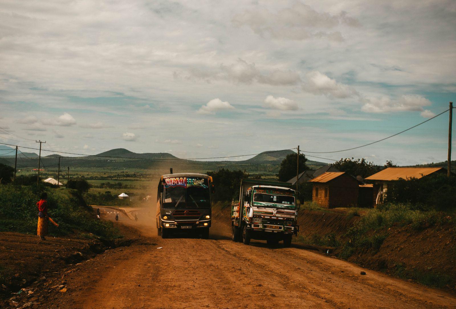 Trucks on a dirt road in rural Tanzania